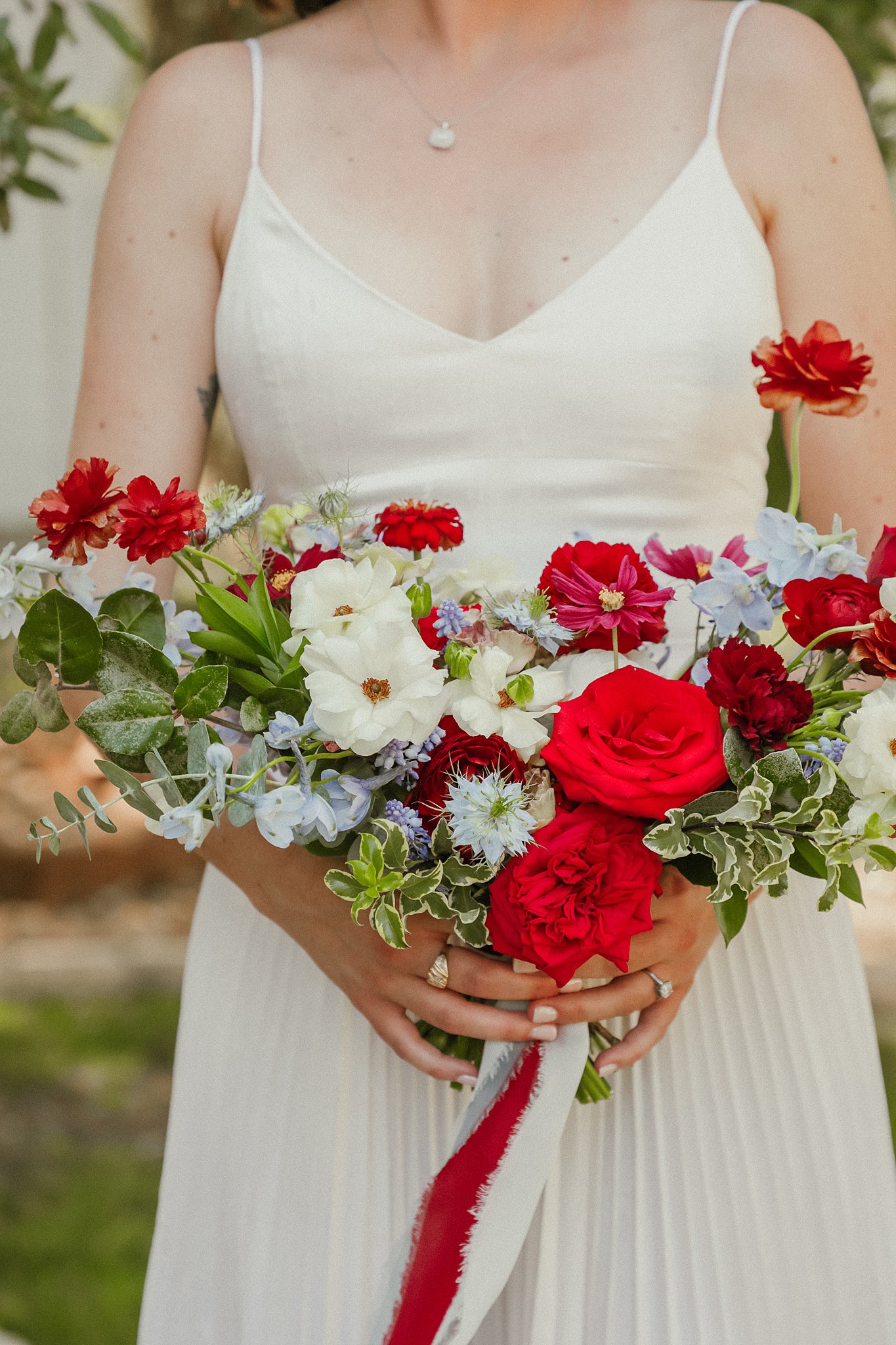 A bride with an Americana-inspired bouquet of red, white, and blue flowers.