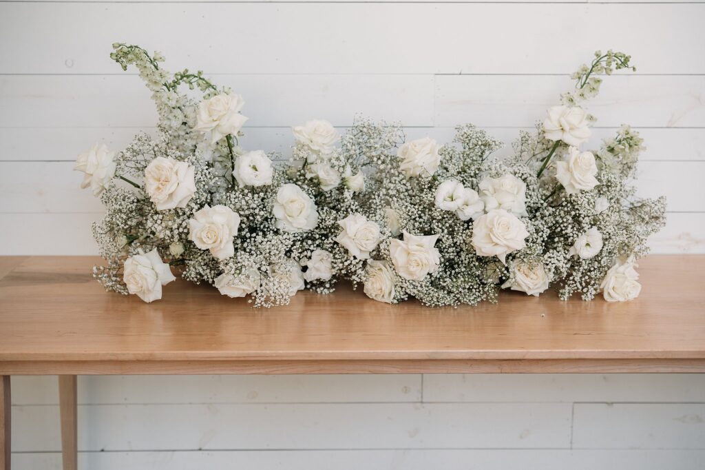 An arrangement of white flowers on a table at a black and white wedding.