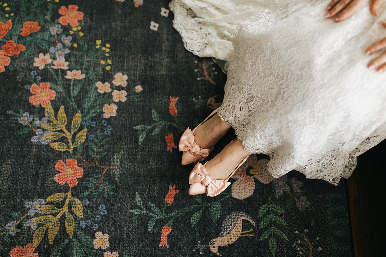 A bride, under the supervision of an Austin Wedding Planner, elegantly poses on a rug showing off her wedding shoes.