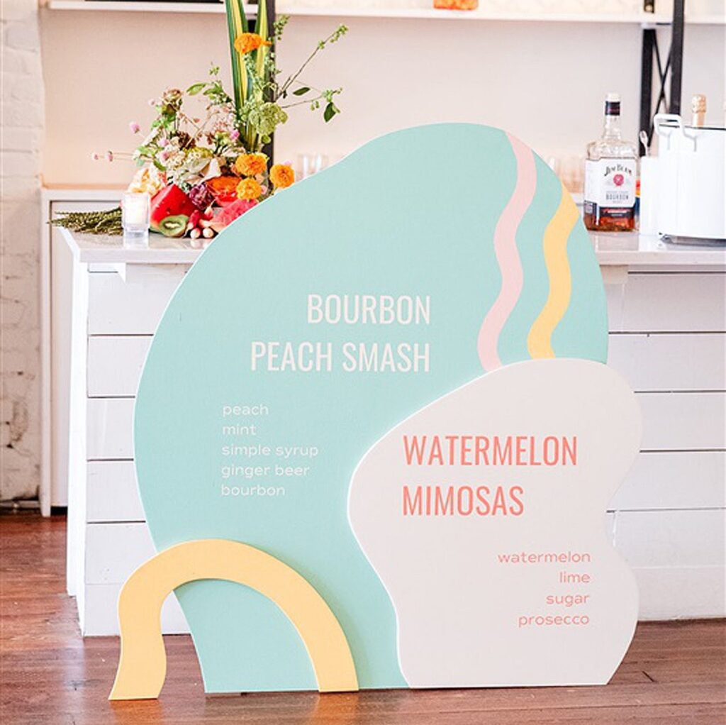 A wedding sign featuring bourbon peach smash and watermelon mimosas.
