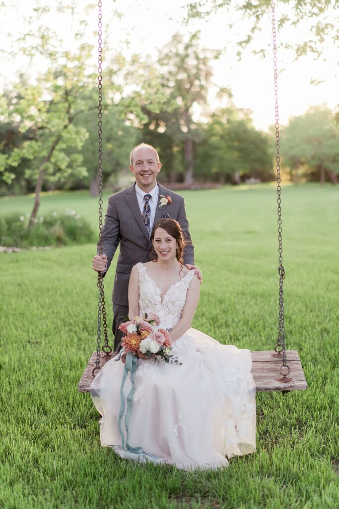 A bride and groom swinging at Pecan Springs Ranch.
