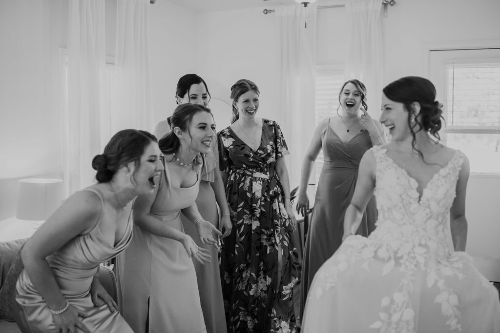 A bride and her bridesmaids laughing at Pecan Springs Ranch.