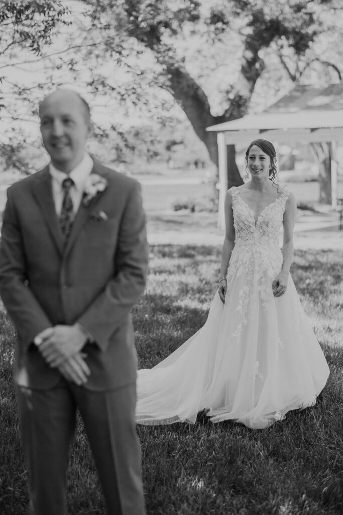 Black and white photo of a bride and groom in front of a tree at Pecan Springs Ranch.