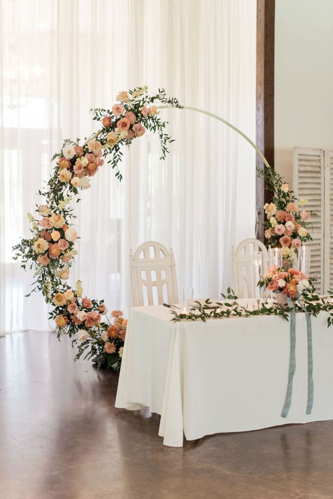 A Pecan Springs Ranch table with a floral arch in the middle.