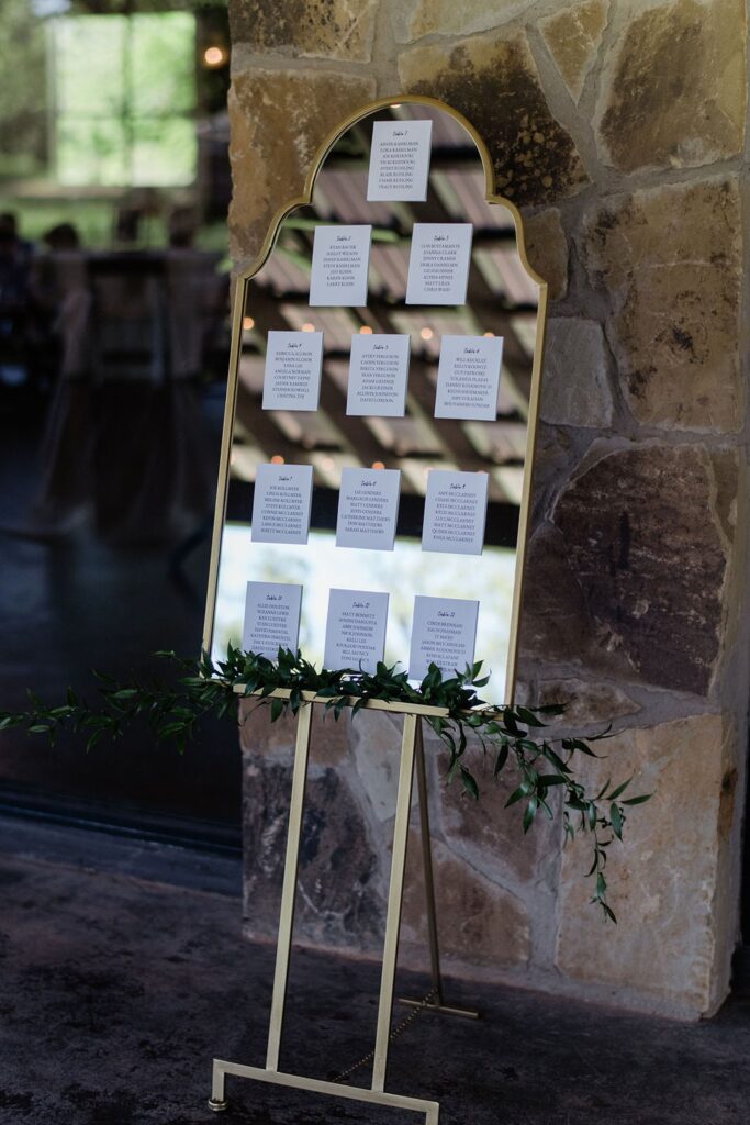 A Pecan Springs Ranch mirror with a place card on it in front of a stone wall.