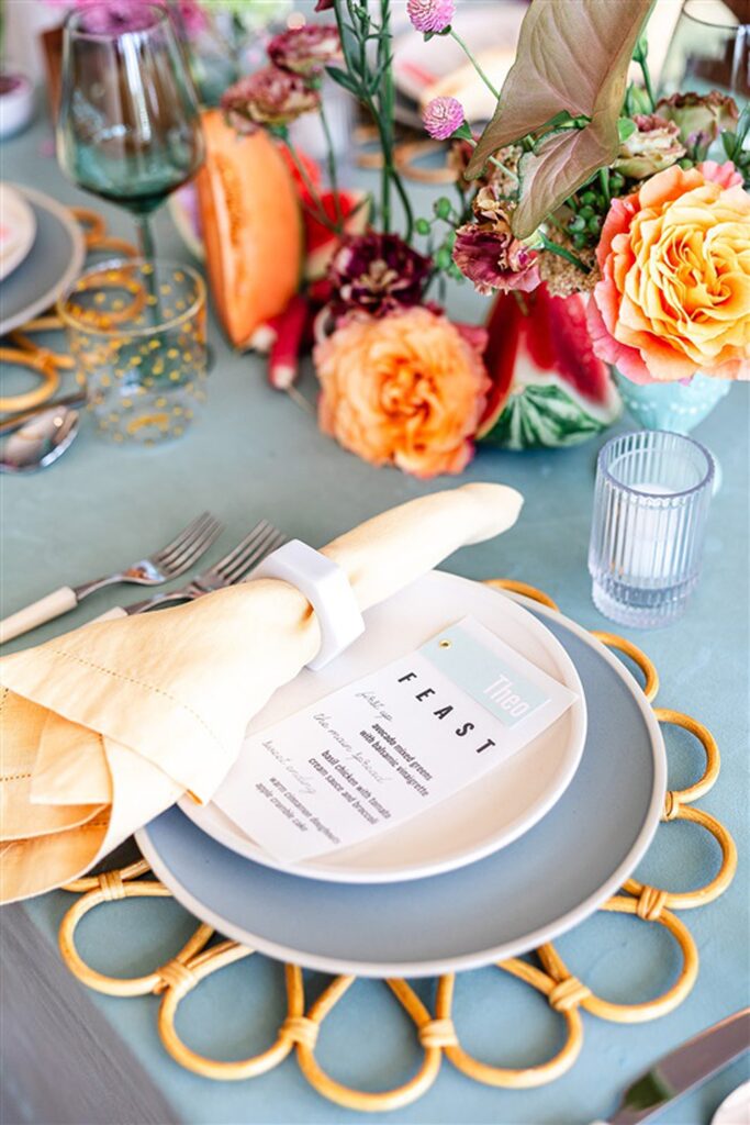 A wedding table setting with plates and napkins on a blue table.