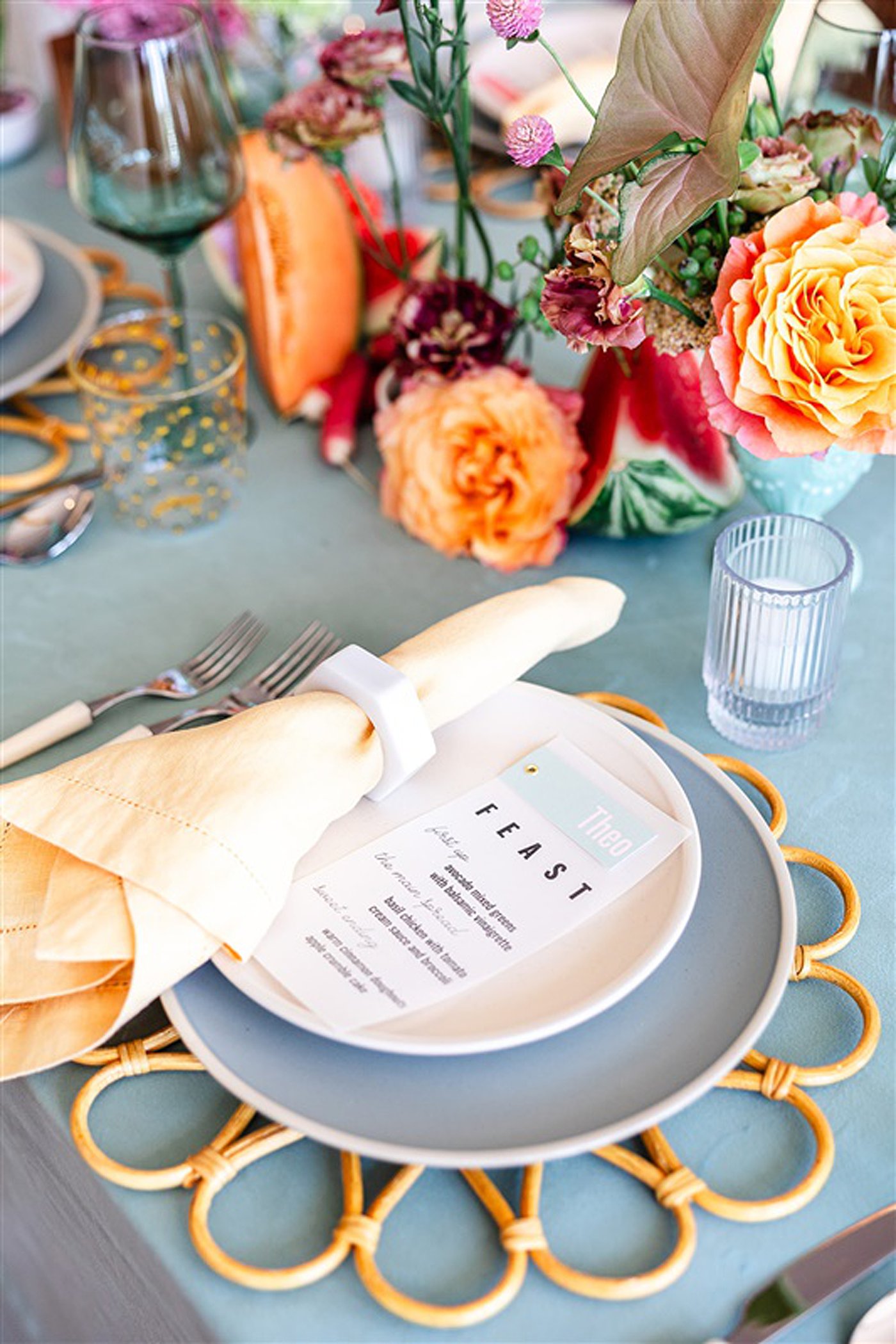 A sustainable wedding table setting with plates and napkins on a blue table.