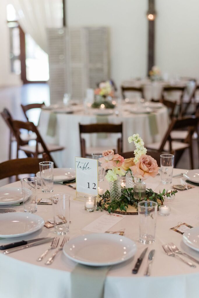 A wedding reception table setting at Pecan Springs Ranch with white plates and napkins.