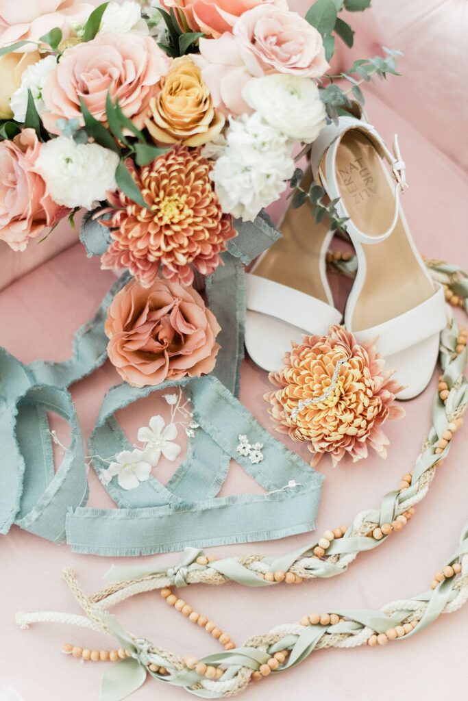 A bride's bouquet and shoes are laid out on a bed at Pecan Springs Ranch.