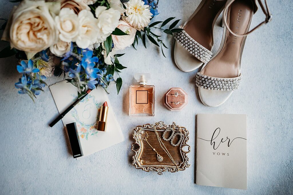 A bride's shoes and accessories are laid out on a table.