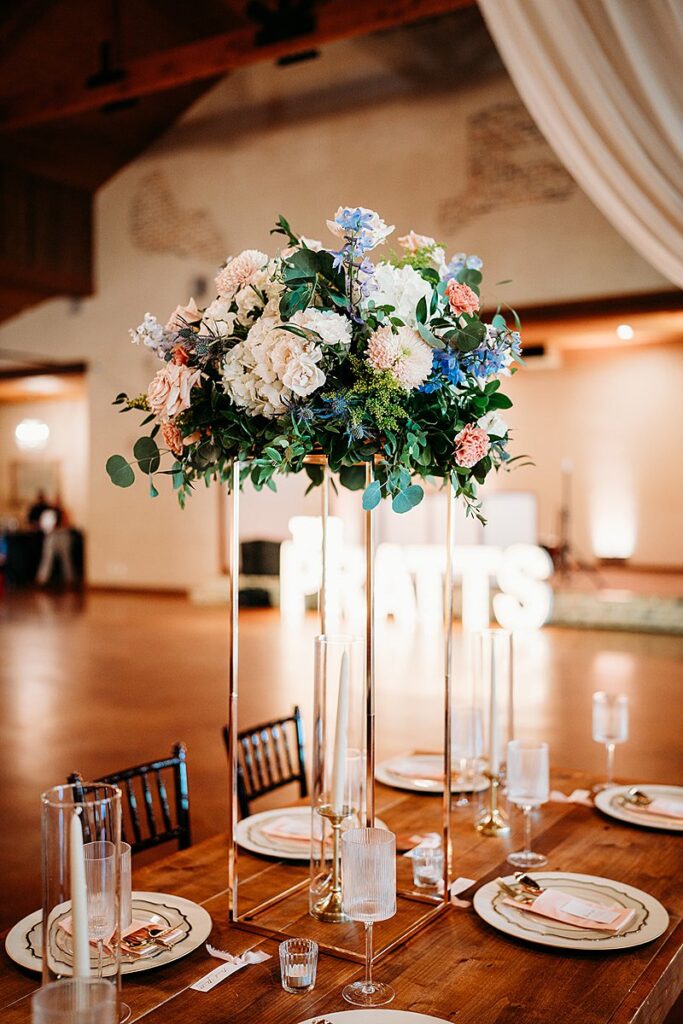 A wedding reception table at The Chandelier of Gruene with a centerpiece of flowers.
