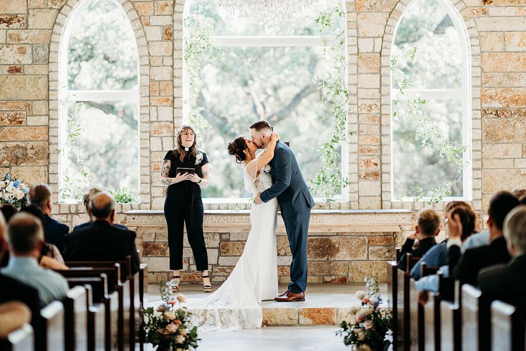 A bride and groom kiss at The Chandelier of Gruene during their wedding ceremony.