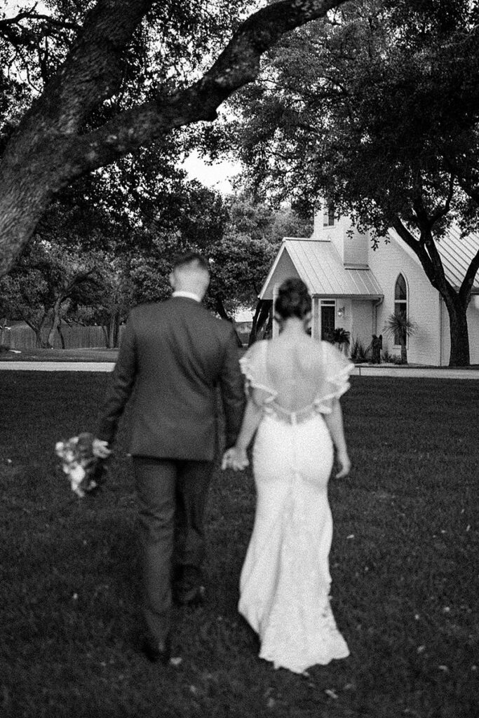 A bride and groom walking in front of The Chandelier of Gruene.