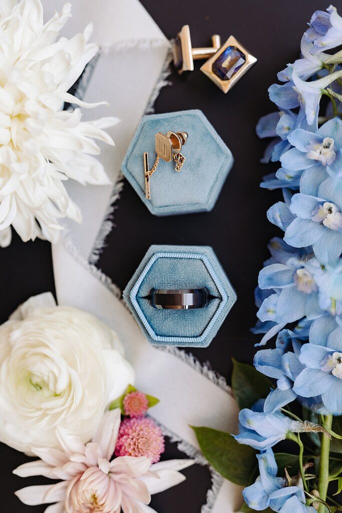 A wedding ring with blue flowers and a blue box.
