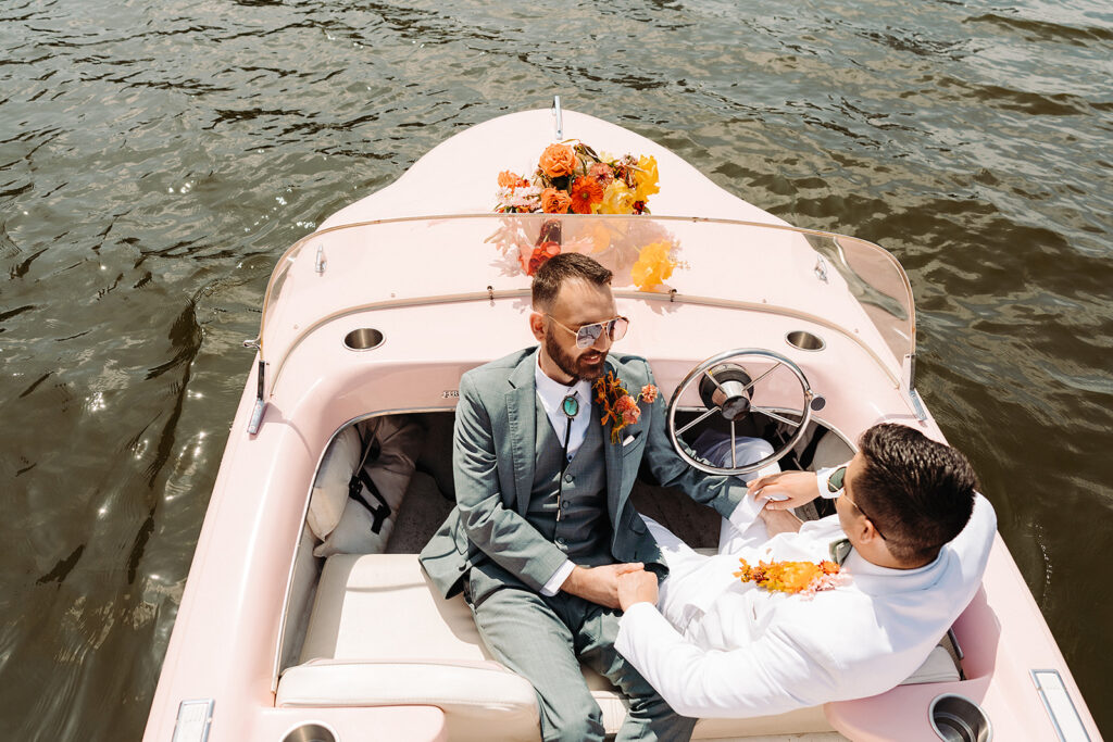 Two men sitting in a boat on the water.
