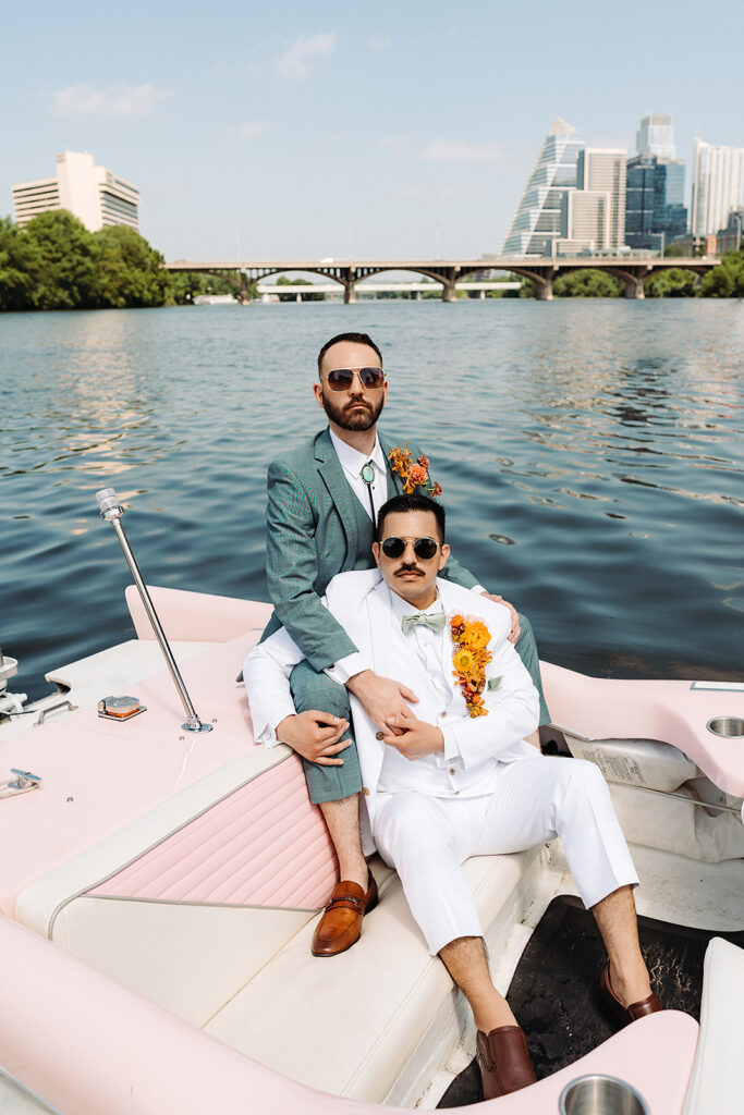 Two men sitting on a pink boat, enjoying the South Congress Hotel Wedding.