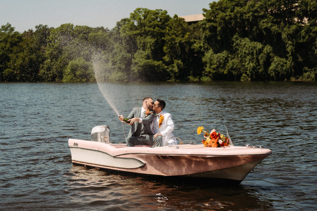 A bride and groom kissing during their South Congress Hotel wedding ceremony, in a pink boat on the water.