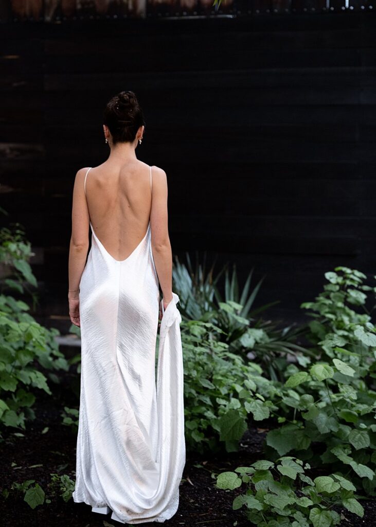 The back of a bride in a white wedding dress.
