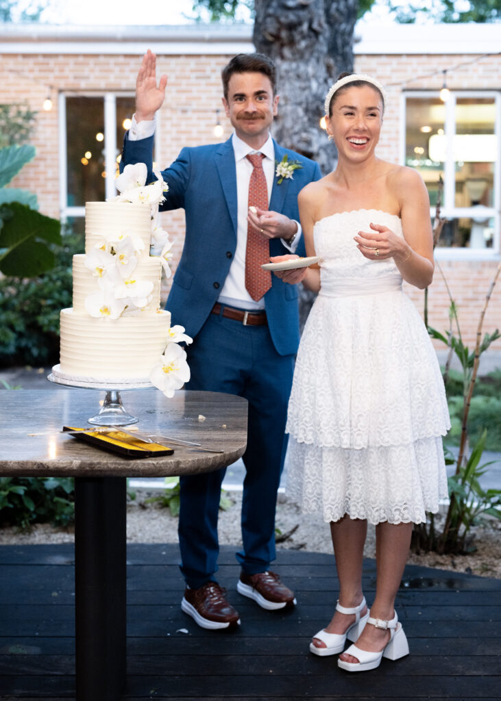 A woman standing next to a wedding cake at a hotel.