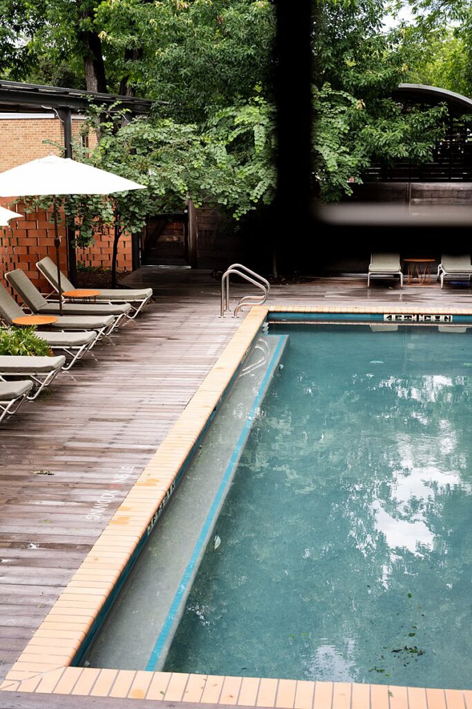 A swimming pool with lounge chairs and umbrellas at the Carpenter Hotel.