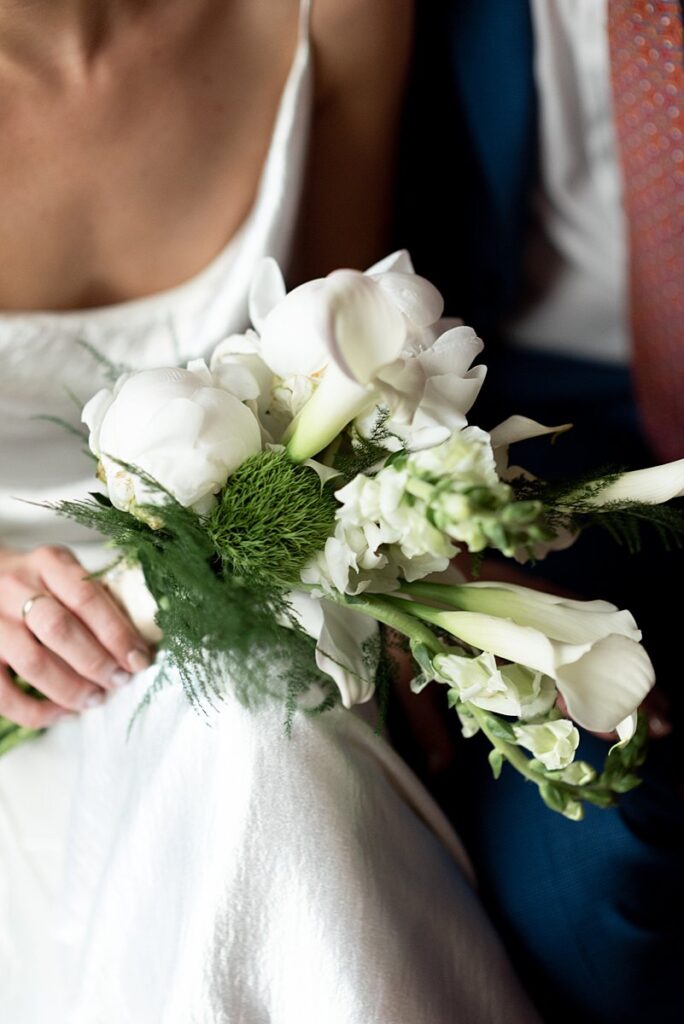 A Carpenter Hotel Wedding with a stunning bride and groom holding a bouquet of white flowers.