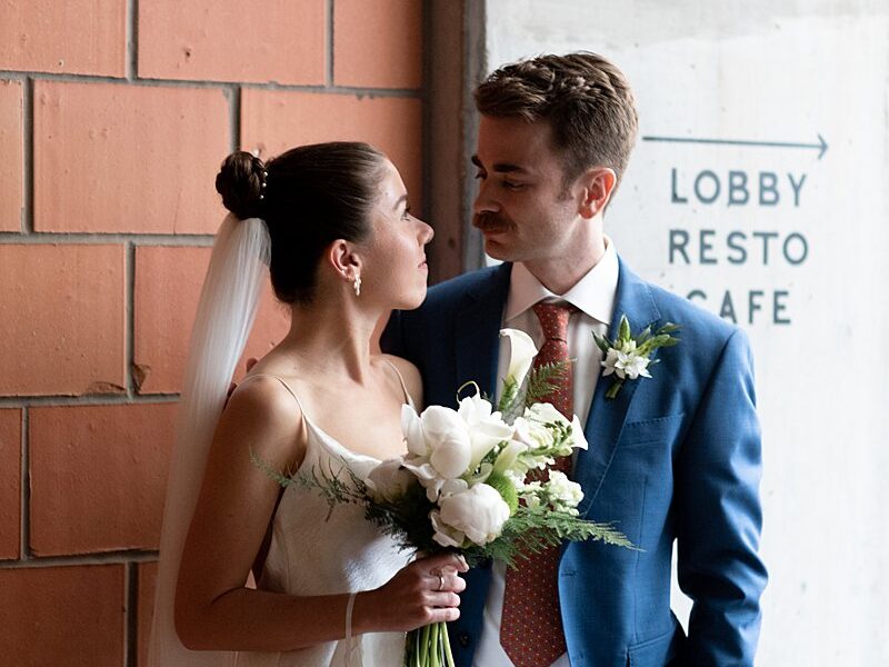 A Carpenter Hotel wedding featuring a bride and groom standing in front of a wall.