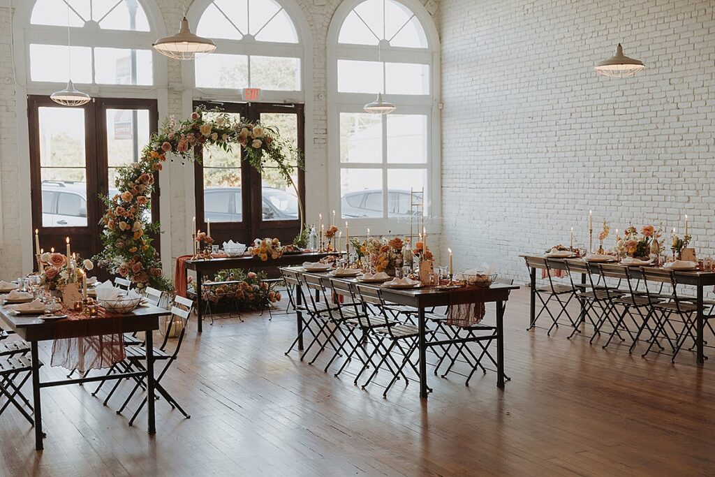 A room with tables and chairs set up for a One Eleven East wedding reception.