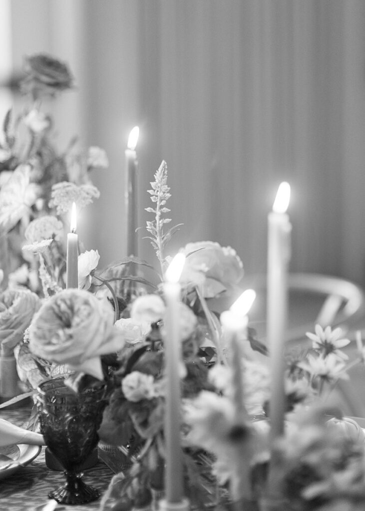 A black and white photo of a table adorned with candles and flowers at Hotel Magdalena wedding.