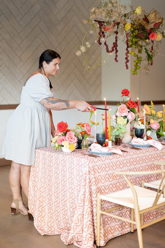 A woman setting up a table for a Hotel Magdalena wedding.