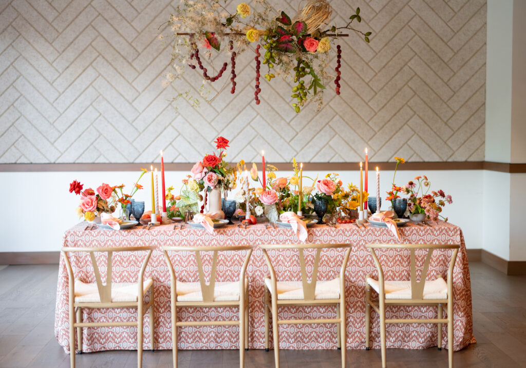 A colorful table setting with flowers and candles.