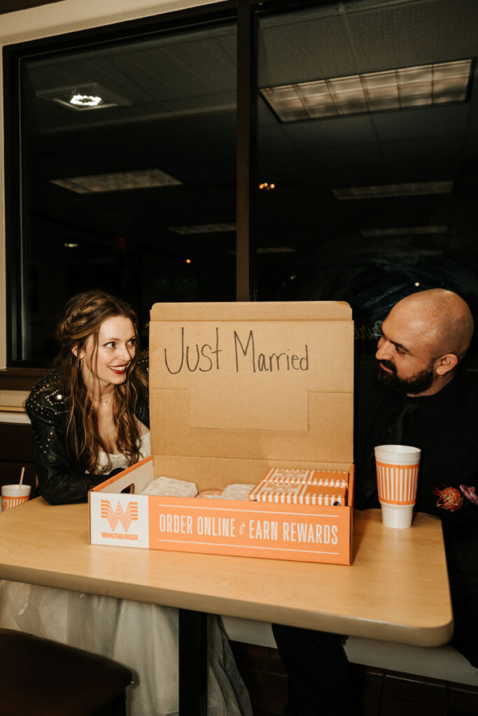 A bride and groom share a Whataburger order with the inside lid of the box saying "Just Married."