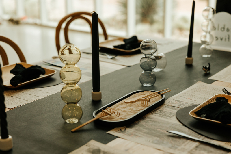 Modern table setting for wedding reception featuring cultural elements and zen sand garden.