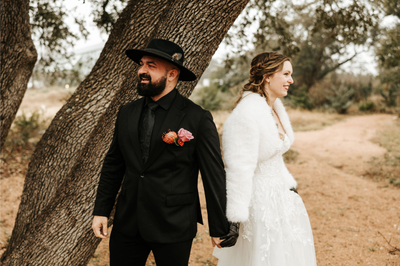 Bride and groom stands holding hands during their first touch.