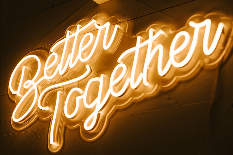 Neon sign displaying the words "Better Together" in cursive script on a wall.