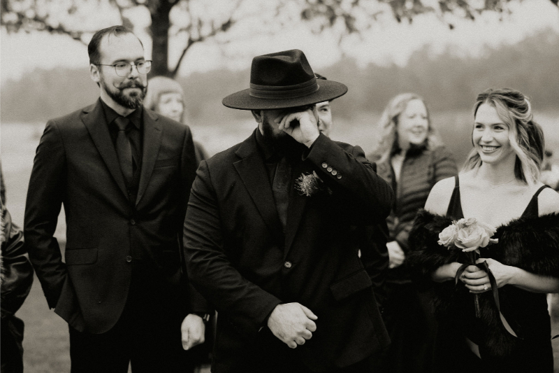 Groom wiping away a tear as his bride walks down the aisle during wedding at Prospect House. 