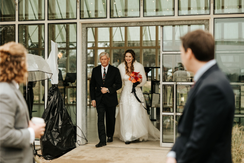 Bride is escorted by her father down the aisle. 