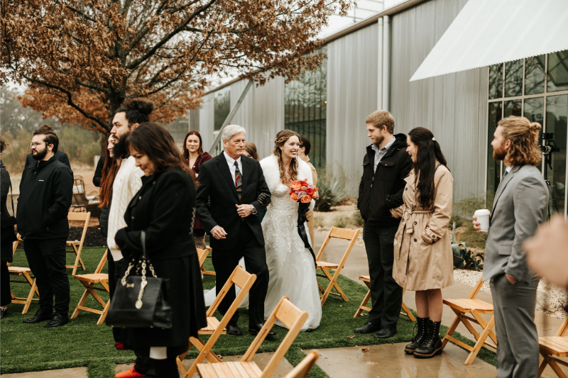 Bride is escorted by her father down the aisle. 