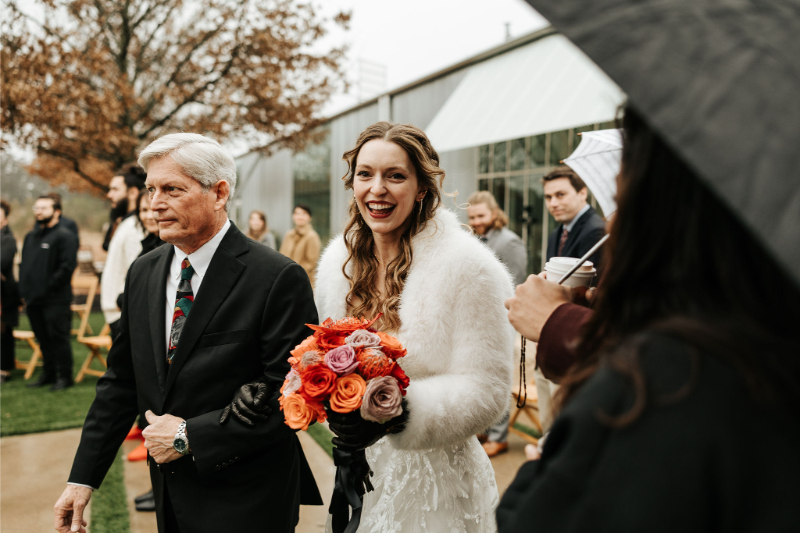 Bride is escorted by her father down the aisle. 