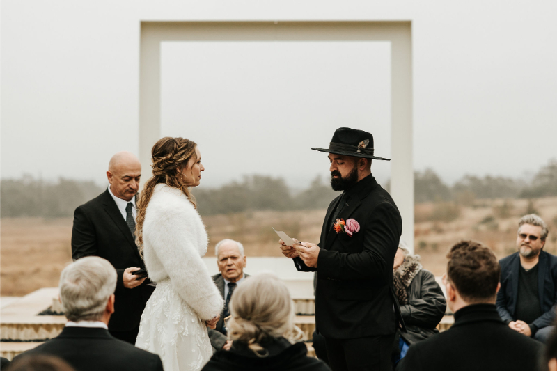 Bride and groom exchange vows during outdoor ceremony. 