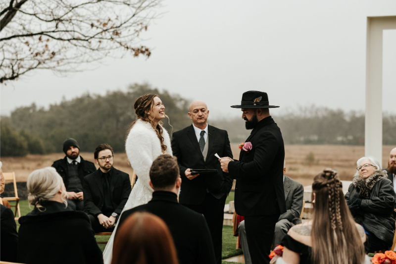 Bride and groom exchange vows during outdoor ceremony. 