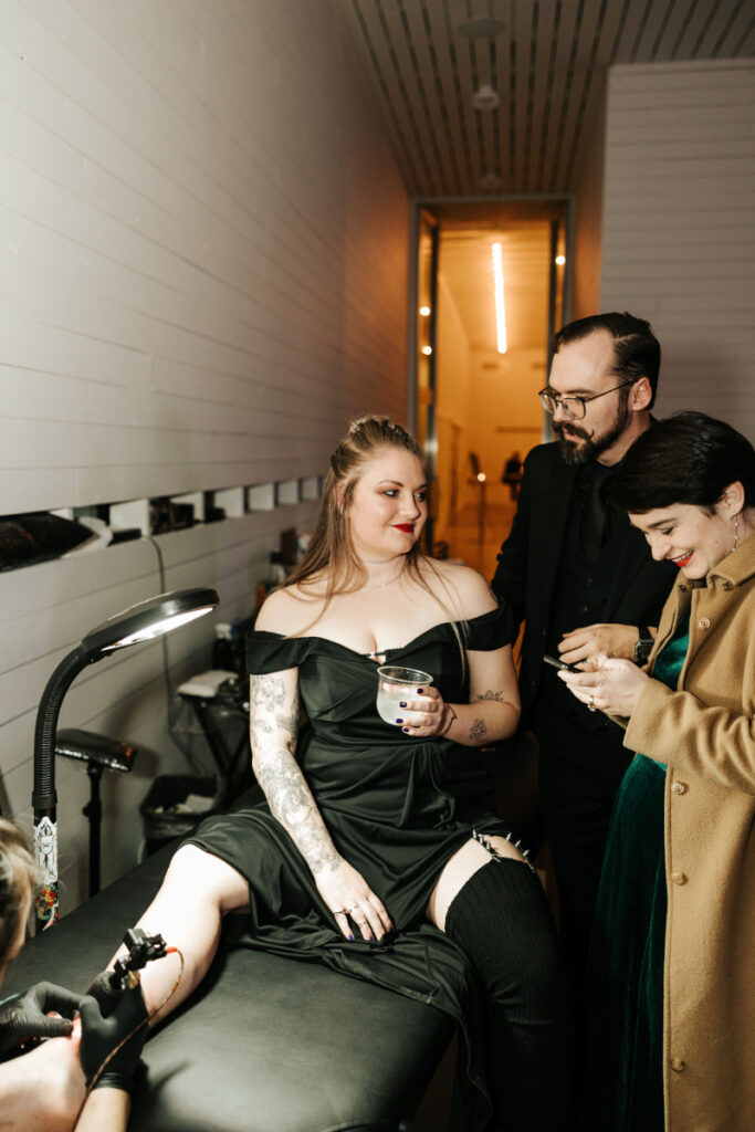 Woman getting a tattoo during a wedding reception. 