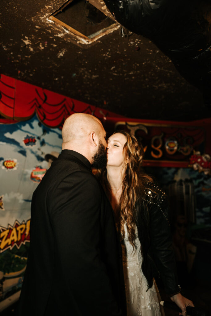 Bride and groom kiss after just singing karaoke together during their wedding afterparty. 