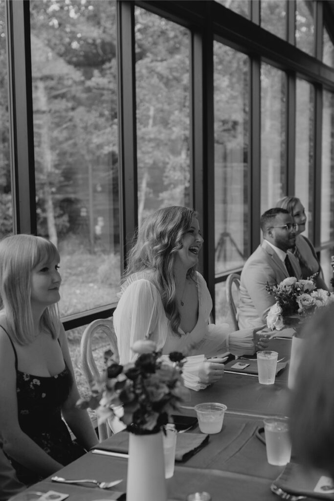 Bride smiles as she watches groom and his mother share dance at their wedding. 