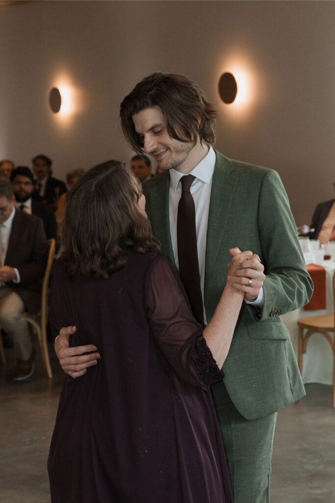 Groom shares dance with mother in the reception hall at The Grand Lady Austin.