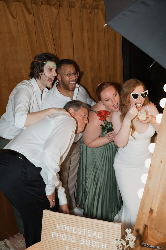 Bride and groom pose with friends in a photo booth for their wedding at the Grand Lady Austin. 