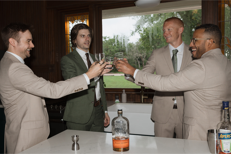 Groomsmen share drink in the kitchen of The Grand Lady Austin.