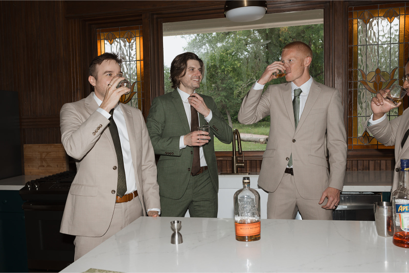 Groomsmen share drink in the kitchen of The Grand Lady Austin.