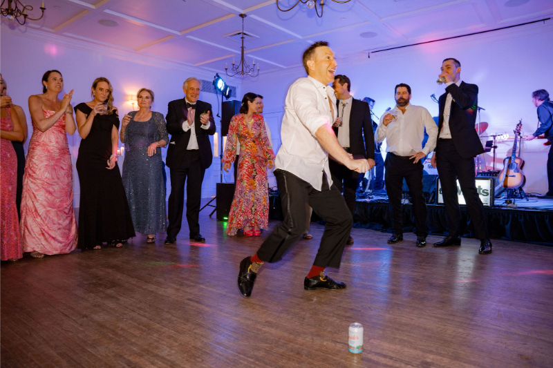 A man dances energetically at wedding reception, showing how incorporating live entertainment is what guests will remember most about your wedding.