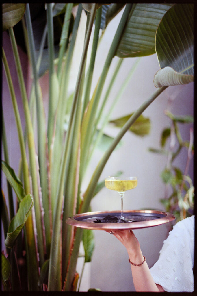 A server passing a signature cocktail att a wedding.