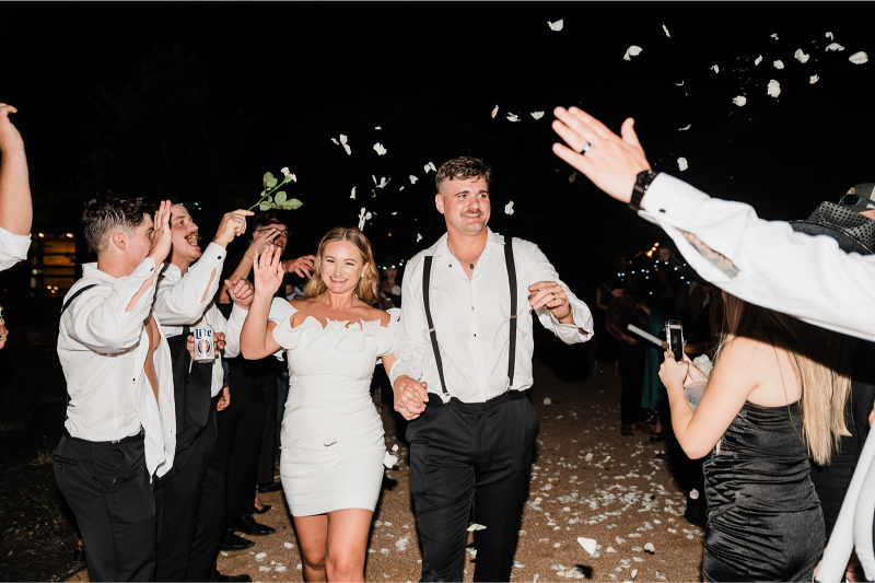 Bride and groom rewriting modern wedding traditions by switching up their outfits for the grand exit.
